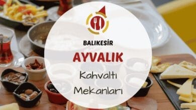 Ayvalık taş sokakta ahşap masada zeytinyağı çeşitleri ve Ege otlu yumurta bulunan kahvaltı tabağı