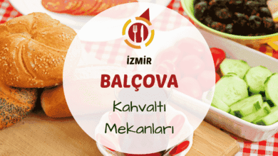 Balçova teleferik bölgesinde yeşillik içinde serpme kahvaltı sunan bir mekanın açık bahçe masası